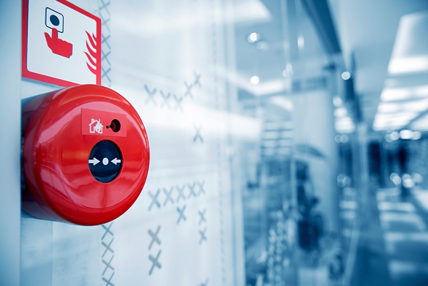 A red fire alarm on a gray wall
