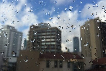 A city view through a window pane filled with water droplets