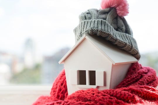 house with a grey hat and red scarf wrapped around it