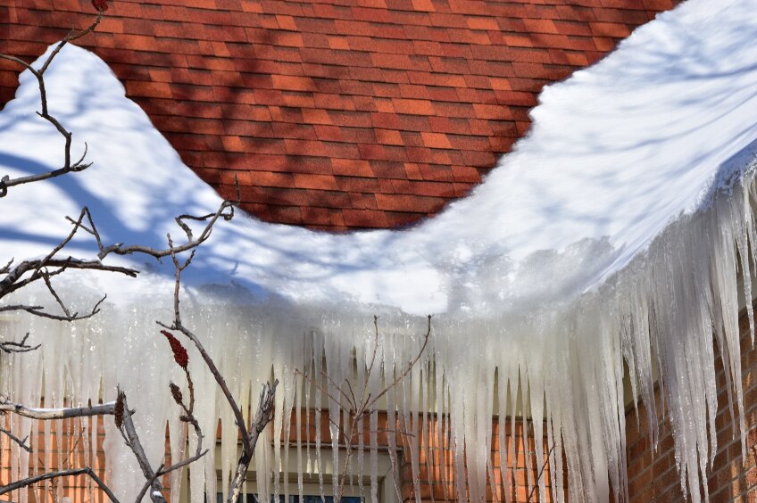 A heavy ice dam formed along a roof's eaves.