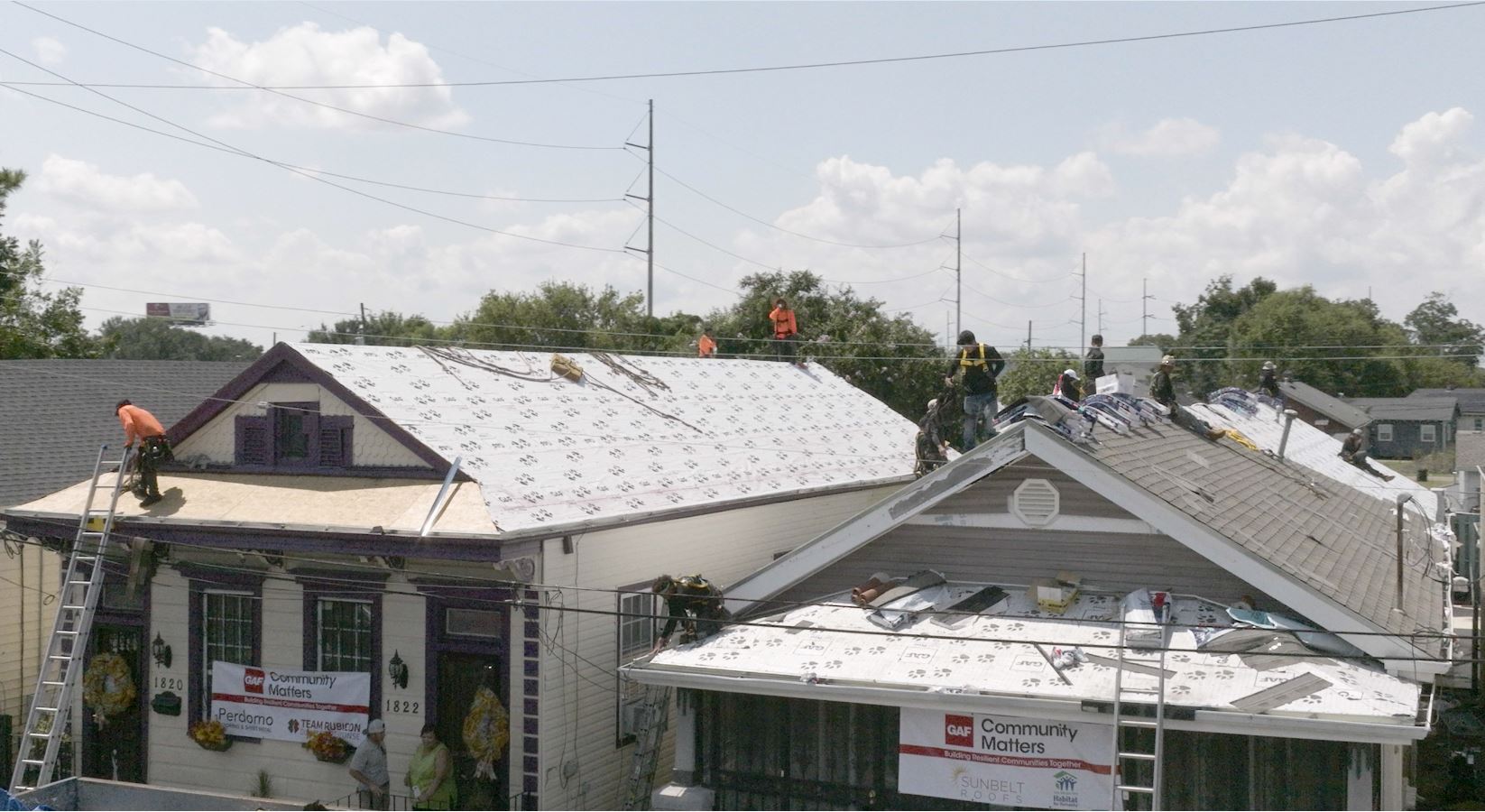 A roofer on working on a tarp-covered roof