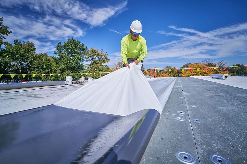 Self-adhered TPO being installed on commercial roof