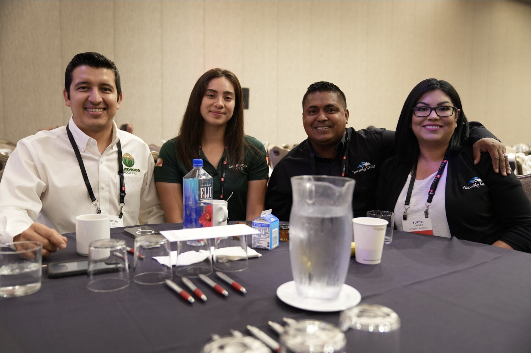 A group of 4 LIR Expo attendees smile at an event table together.
