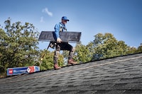 A roofer in the process of installing GAF shingles on a roof