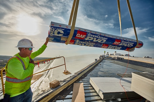 Roofers install a GAF EverGuard PVC roofing system.