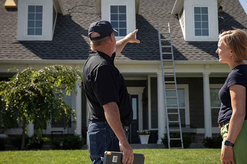 Contractor discussing roof damage with a customer