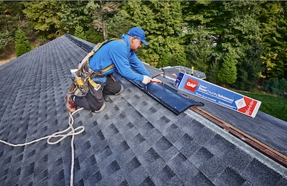 A roofer installs GAF's Cobra SnowCountry Advanced Premium Exhaust Vent on a Roof Ridge