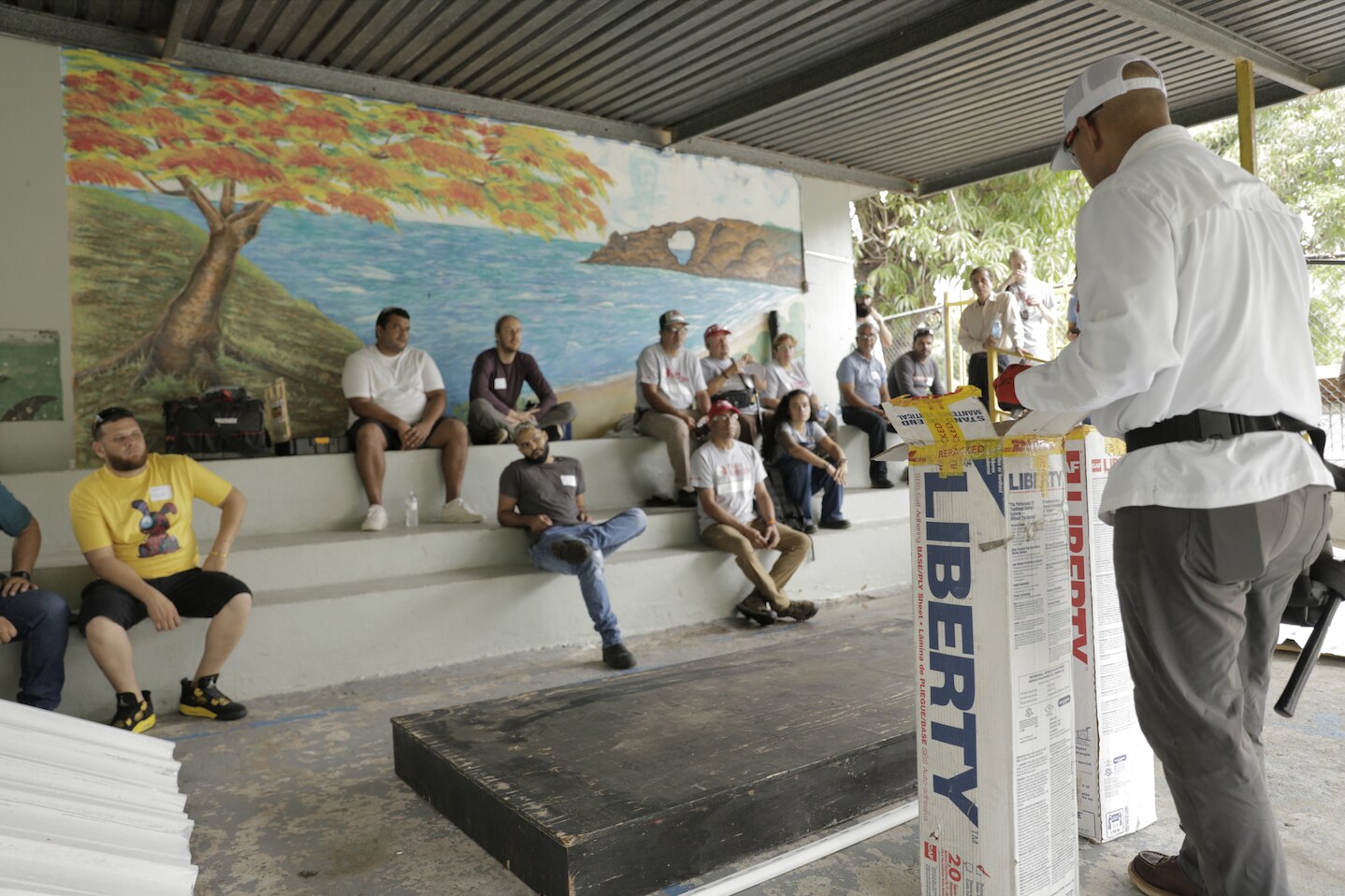 A GAF Roofing Academy instructor teaches memebers of the community in Puerto Rico about roof installaion.