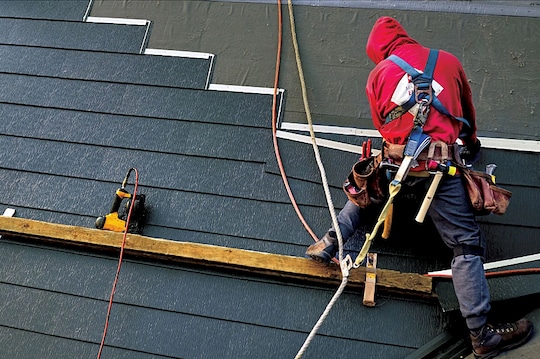 A metal roof system being installed on a home by a roofer.