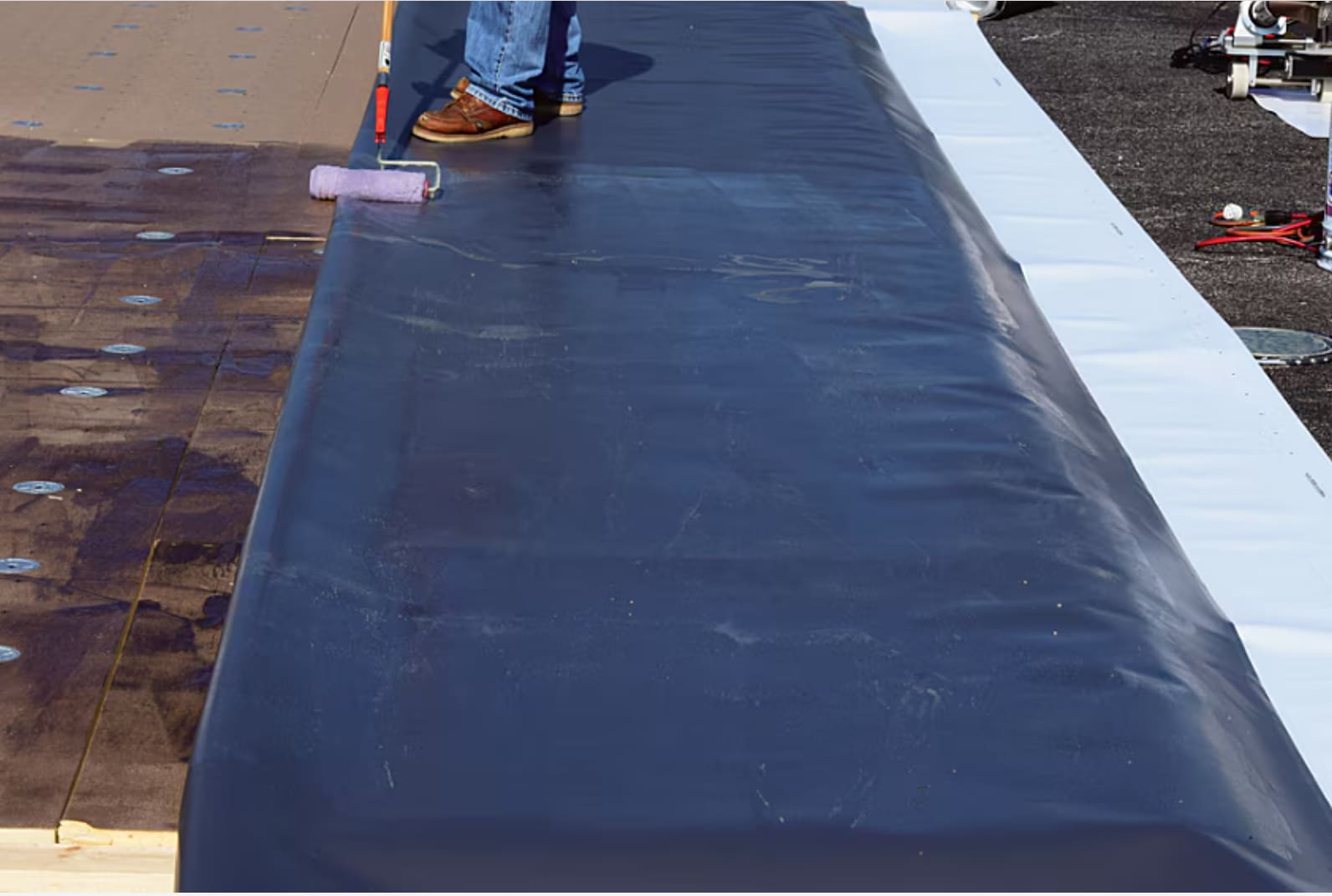 A contractor applying GAF EverGuard® adhesive.