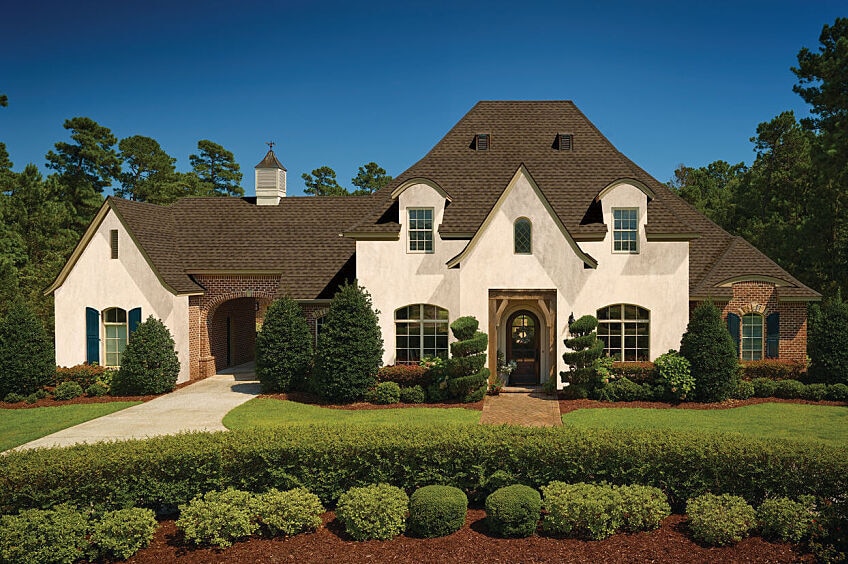 A large house with dark roofing shingles.