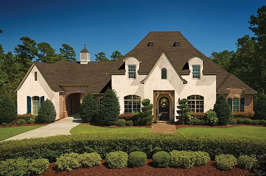 A large house with dark roofing shingles.