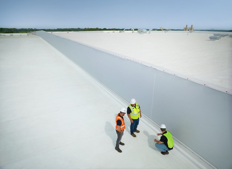 Three contractors inspecting a GAF cool roof installation