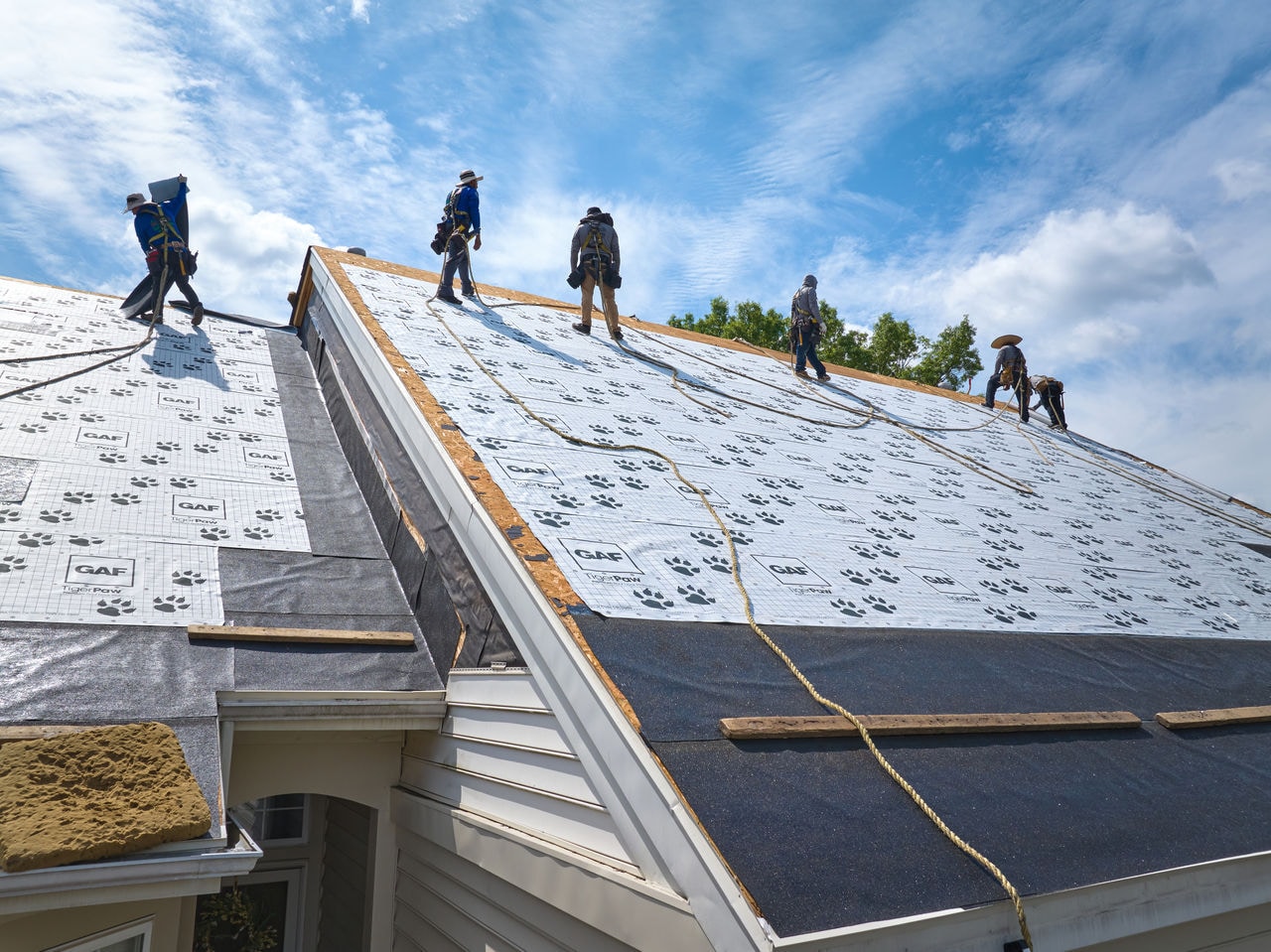 Roofers Installing GAF TigerPaw Underlayment on a Sloped Roof