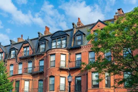 A row of buildings with mansard roofs.