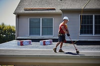 A roofer installs GAF LIBERTY™ Self-Adhering Base/Ply Sheet