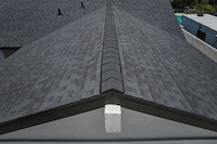 Contemporary house exterior featuring dark reflective shingles.