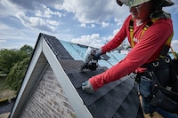 A roofer installs GAF Timberline AS II Shingles on a roof
