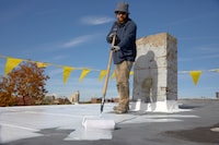 Contractor using a roof coating on a commercial roof