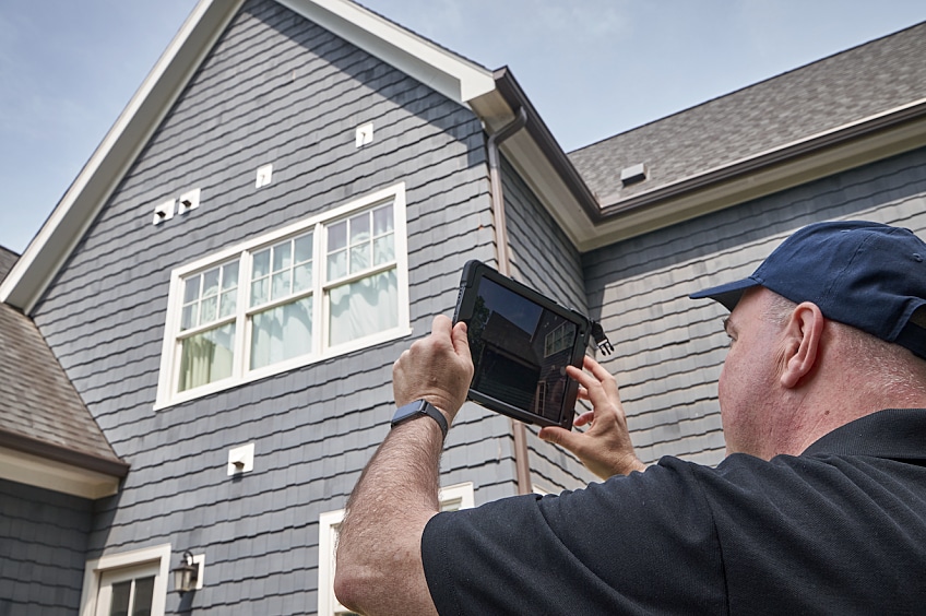 A homeowner is seen taking a picture of his roof