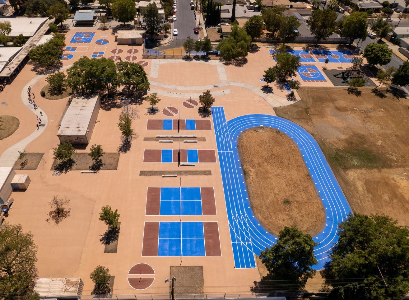 GAF StreetBond® pavement coating in green, white, and blue brightens parking area and diverts heat.