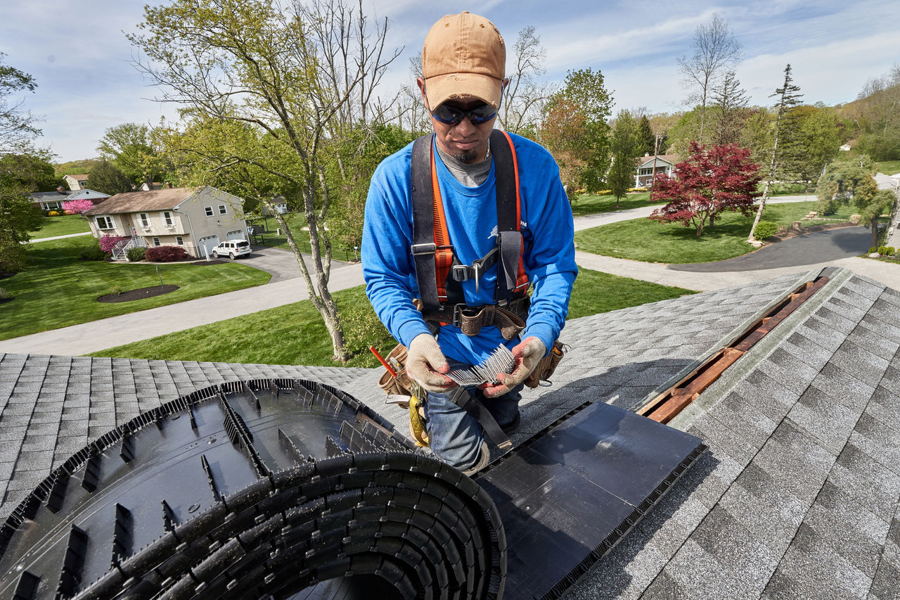 A roofer installing a ridge vent