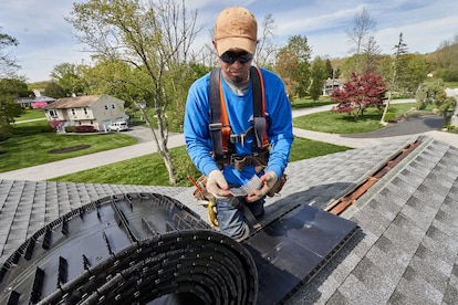 A roofer installing a ridge vent