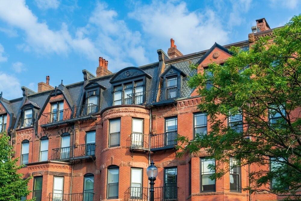 A row of buildings with mansard roofs.