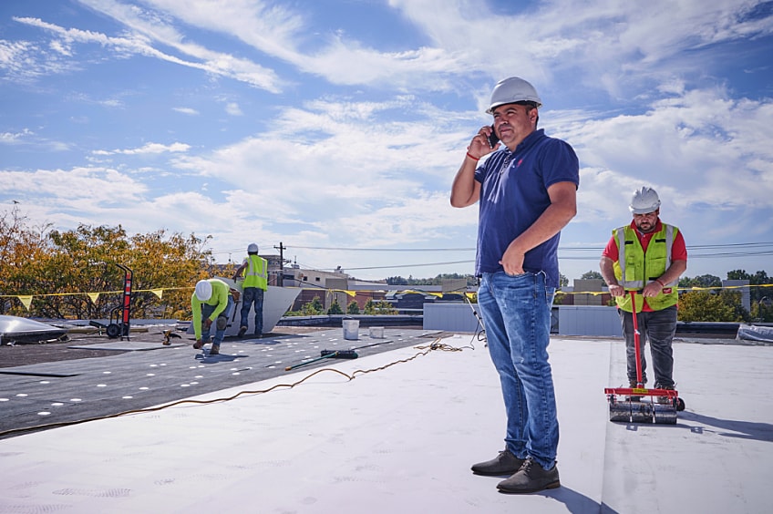 Group of builders makes notes on building plans.