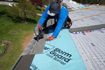 Roofer installing roof shingles over GAF Storm Guard leak barrier