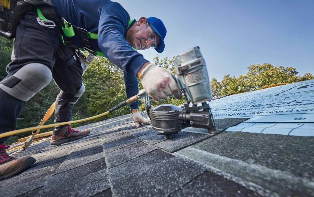 Roofer installing GAF shingles on a roof