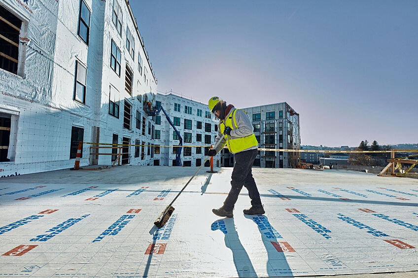 A commercial roofer installs GAF product on a commercial roof