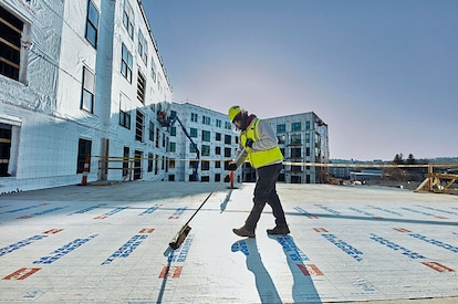 A commercial roofer installs GAF product on a commercial roof