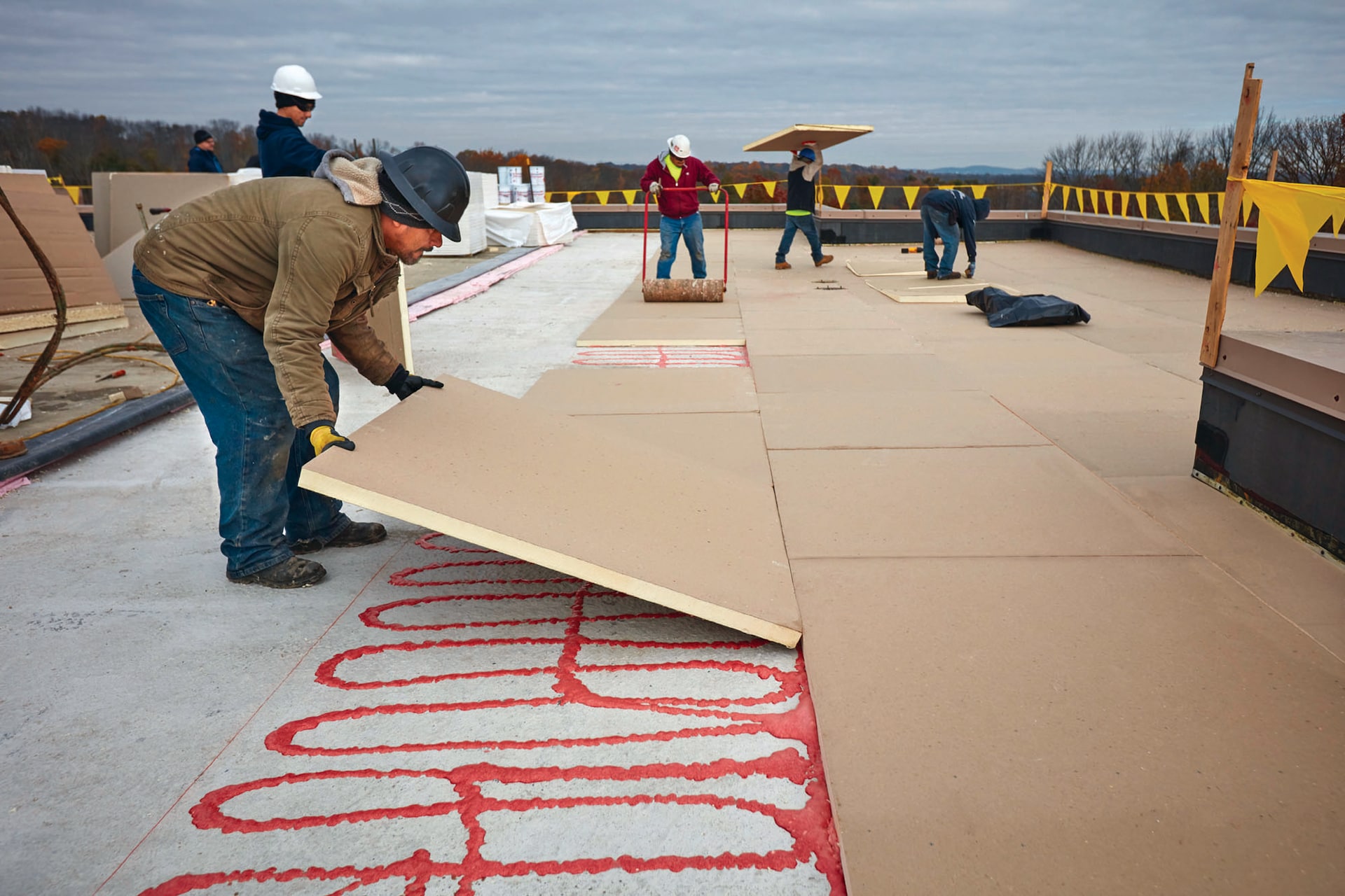 Polyiso insulation being laid down by contractors on roof.