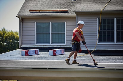 A roofer installs GAF LIBERTY™ Self-Adhering Base/Ply Sheet