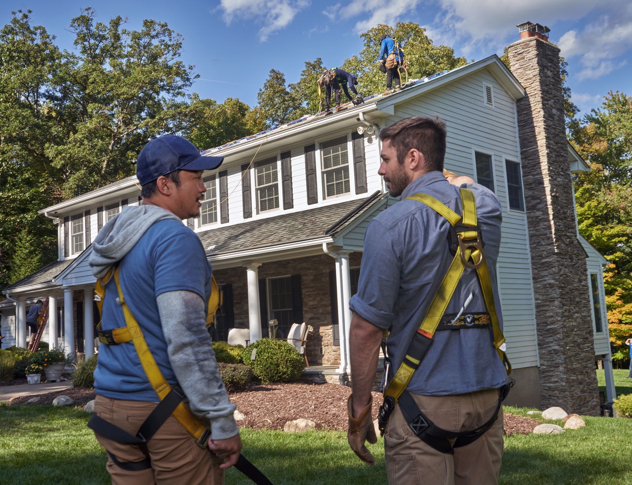 Two Roofers look up at a roof being installed
