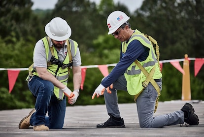 A Roofing Contractor discusses comparing commercial roofing bids with a client. 