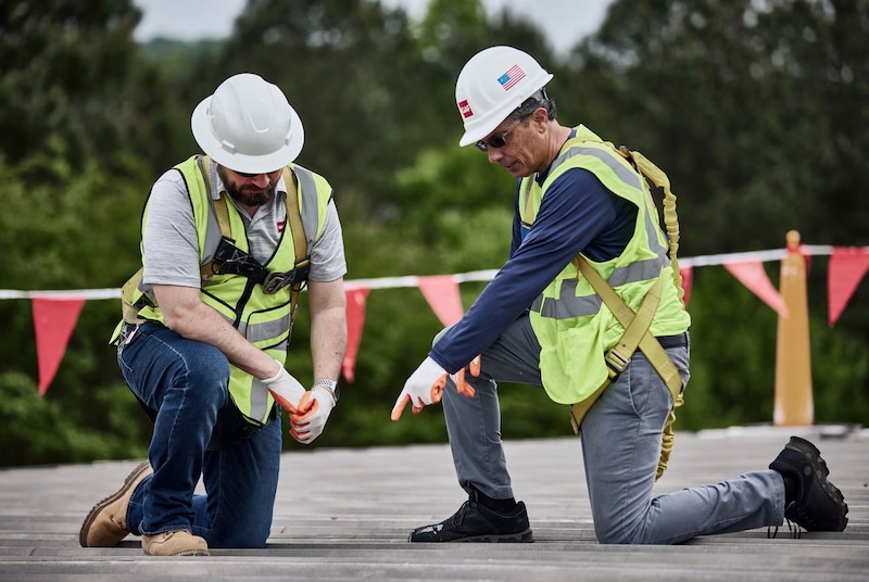 A Roofing Contractor discusses comparing commercial roofing bids with a client. 