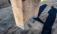A roof cricket: the triangular structure installed behind a chimney, skylight, or other roof protrusion to help divert water.
